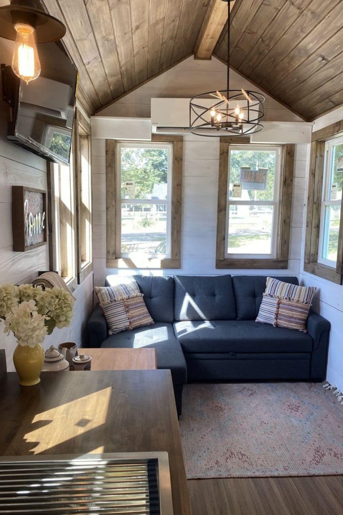 blue sofa under windows at end of tiny home