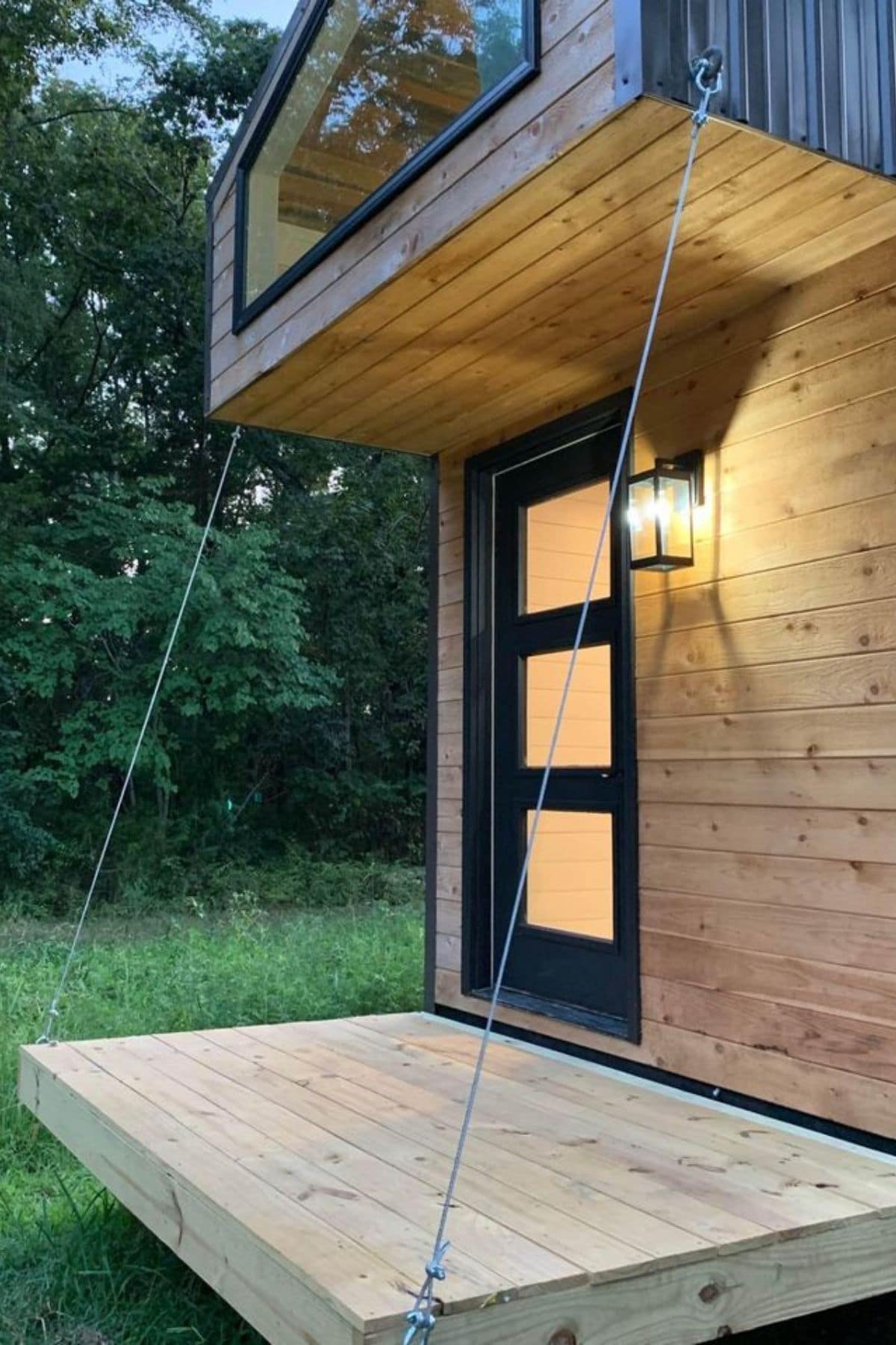 drop down porch with black door against light wood