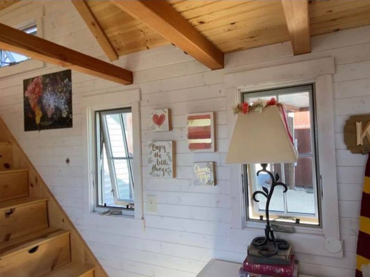 windows and lamp against white shiplap wall inside tiny home