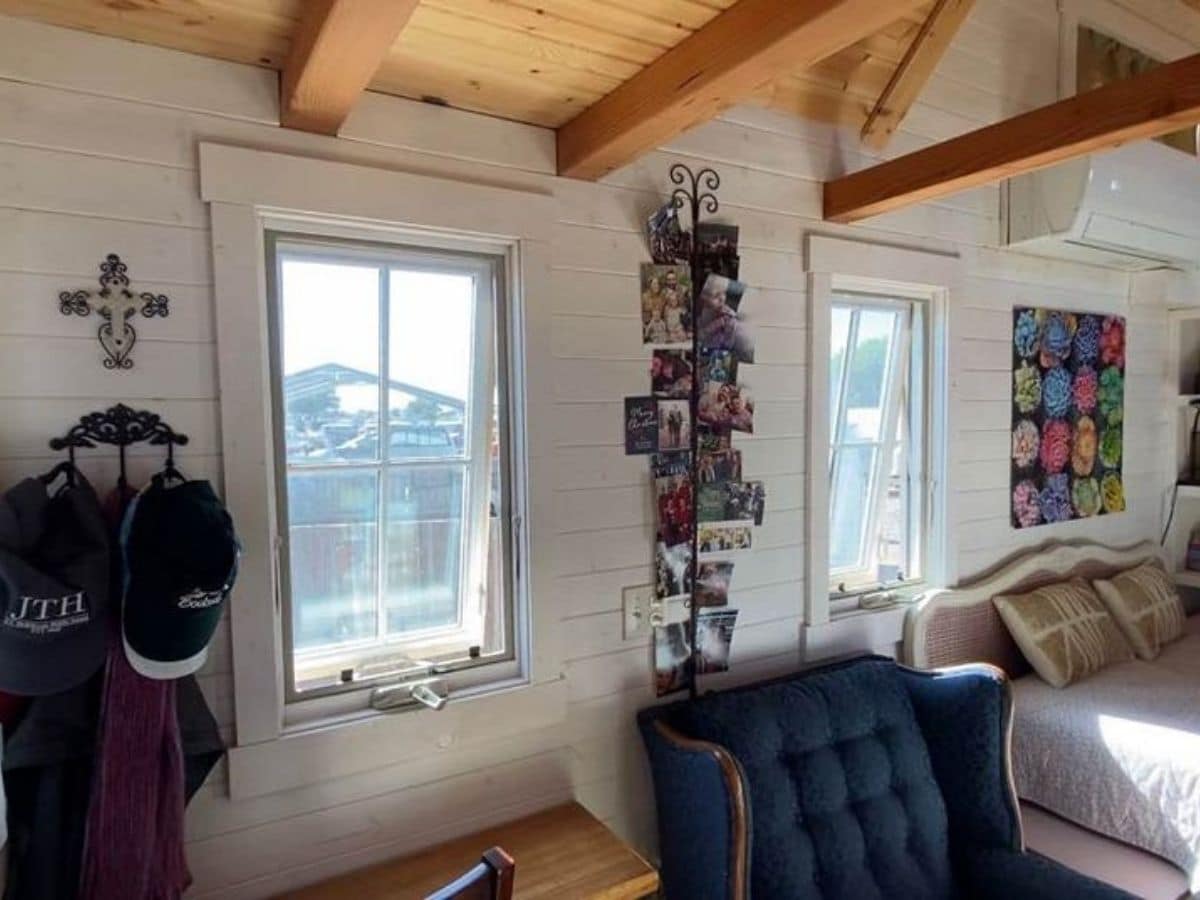 windows behind blue chair with hanging picture holder between windows