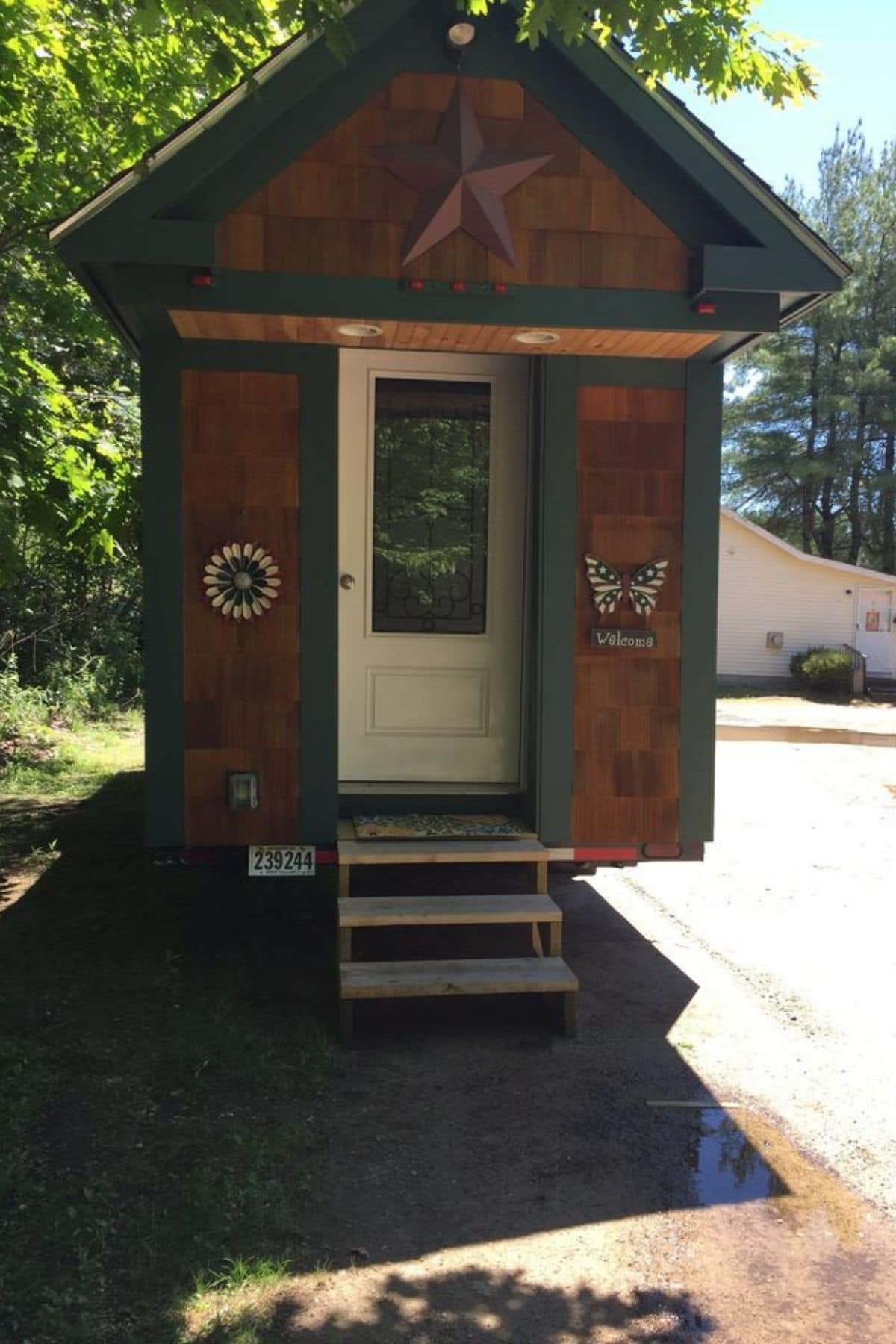 Cedar siding on tiny home with white door and steps on end