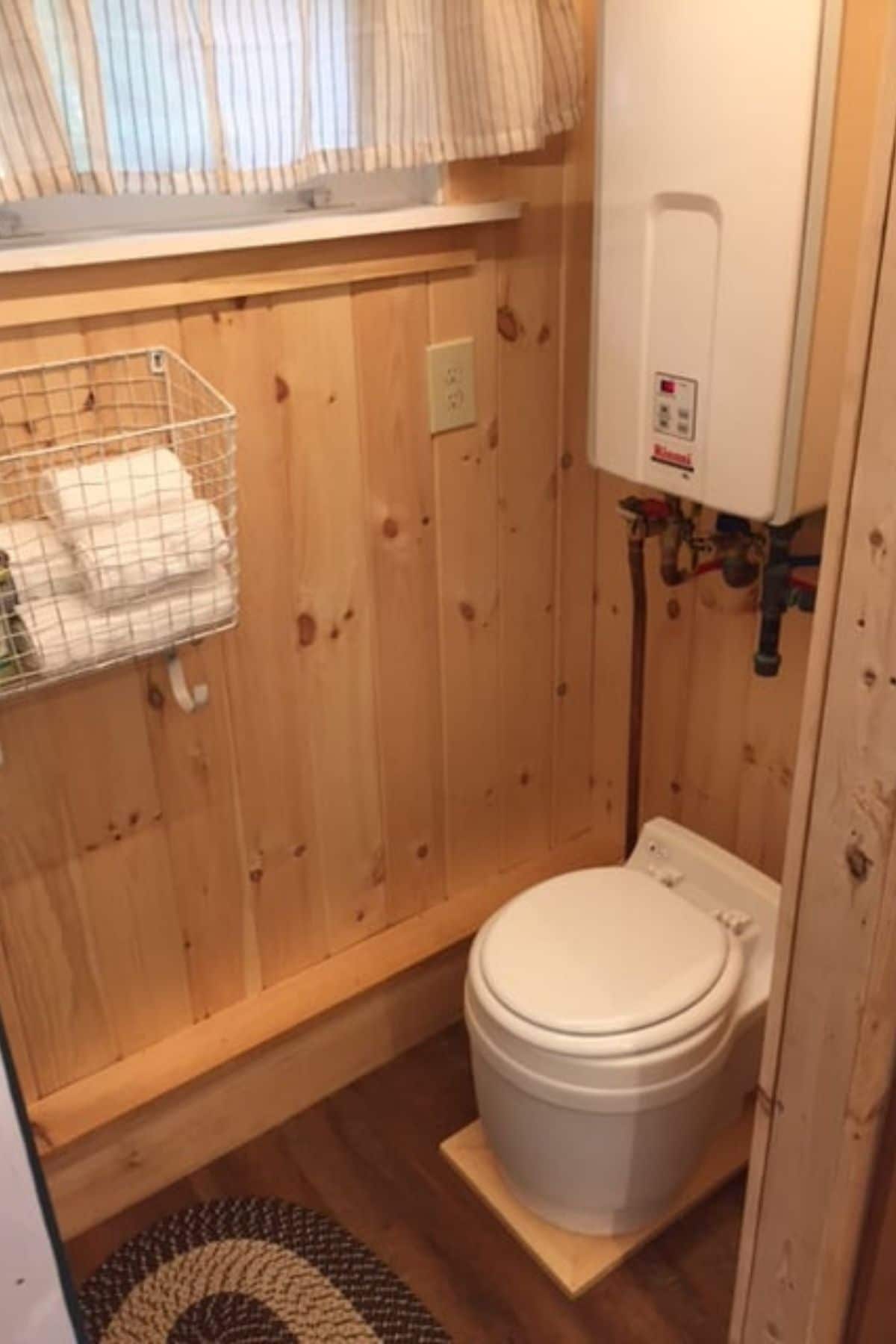 small white toilet against light wood walls in bathroom