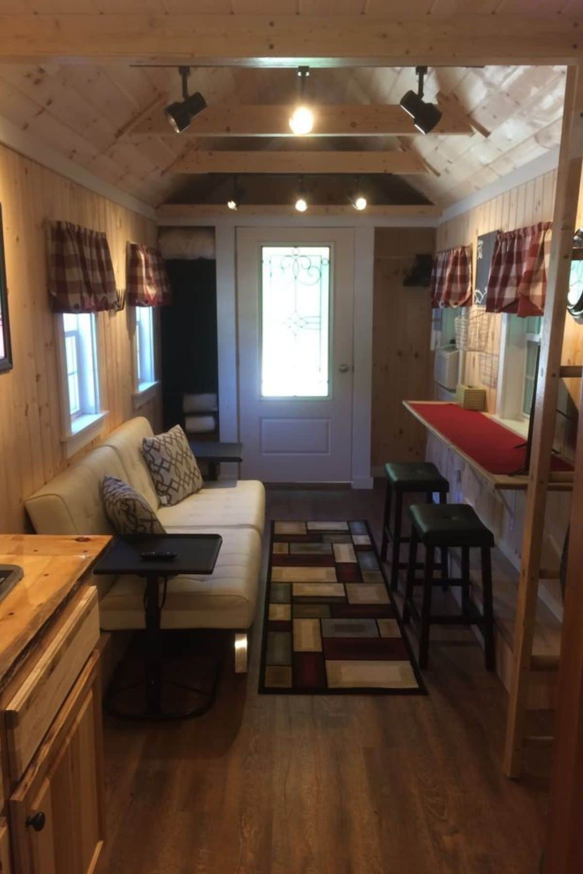 view of front door of tiny home from kitchen looking over living area