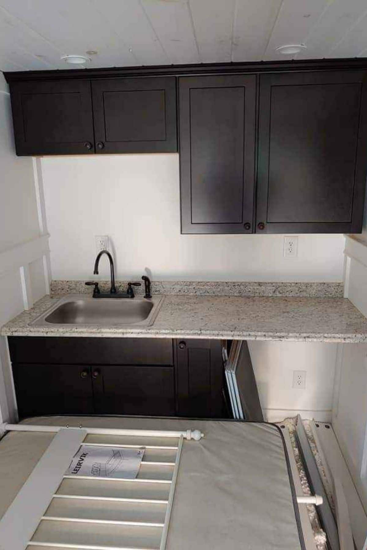 corner kitchen with white counter and dark cabinets