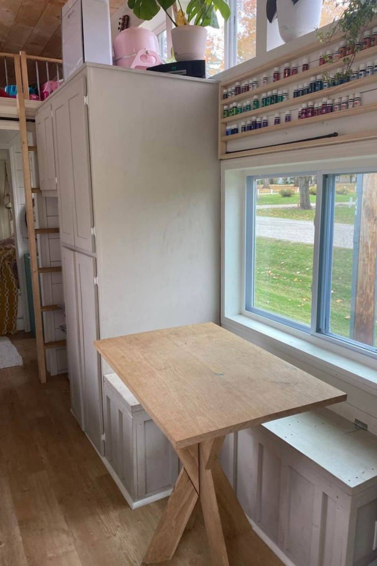 blonde wood table underneath window next to pantry