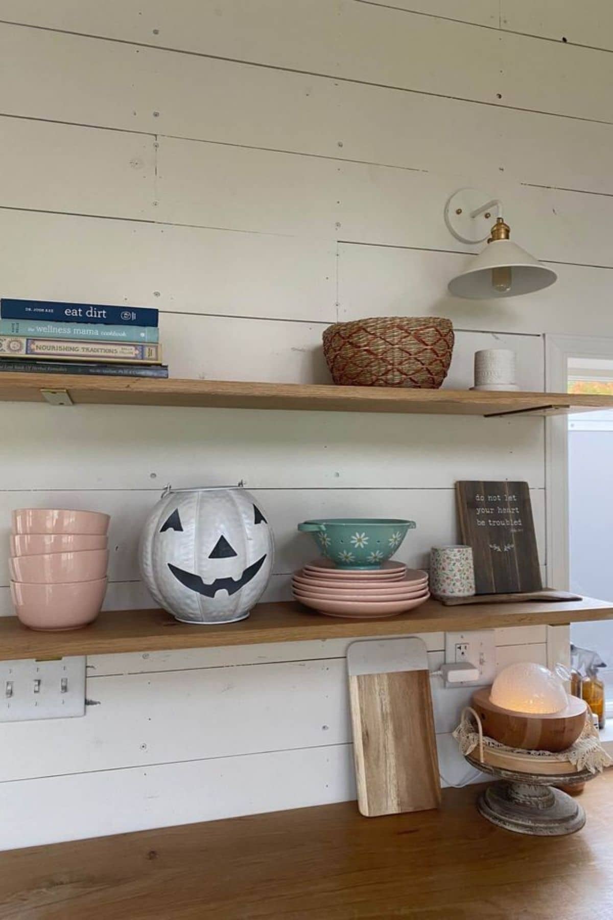 shelves on white shiplap wall with plates and pumpkin decor