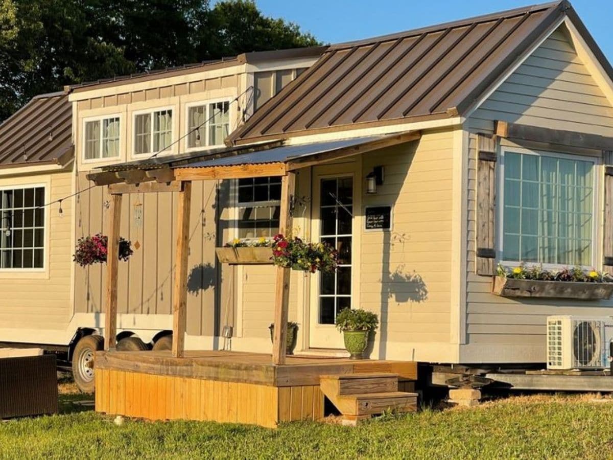 tan siding on tiny house with small wood porch on side
