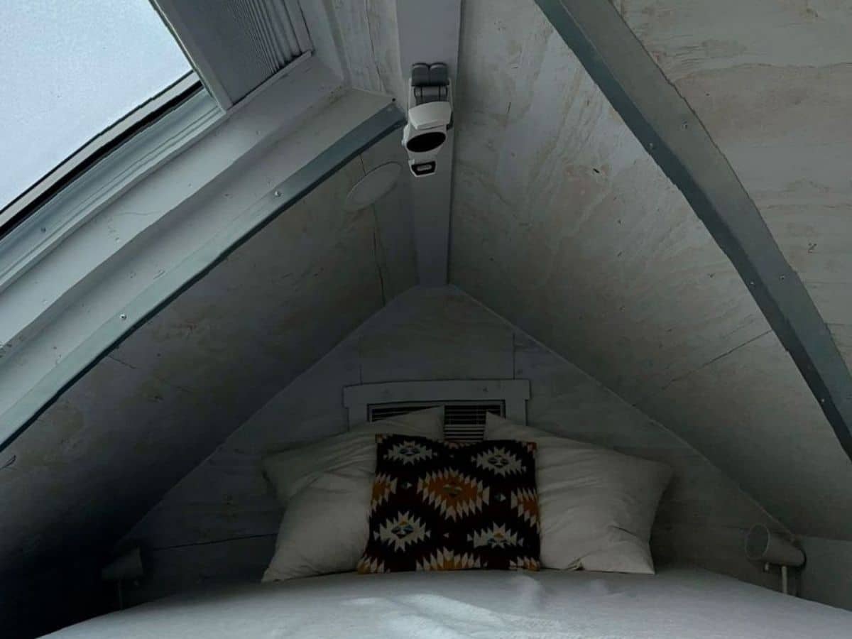 view of bed in loft with skylight to left
