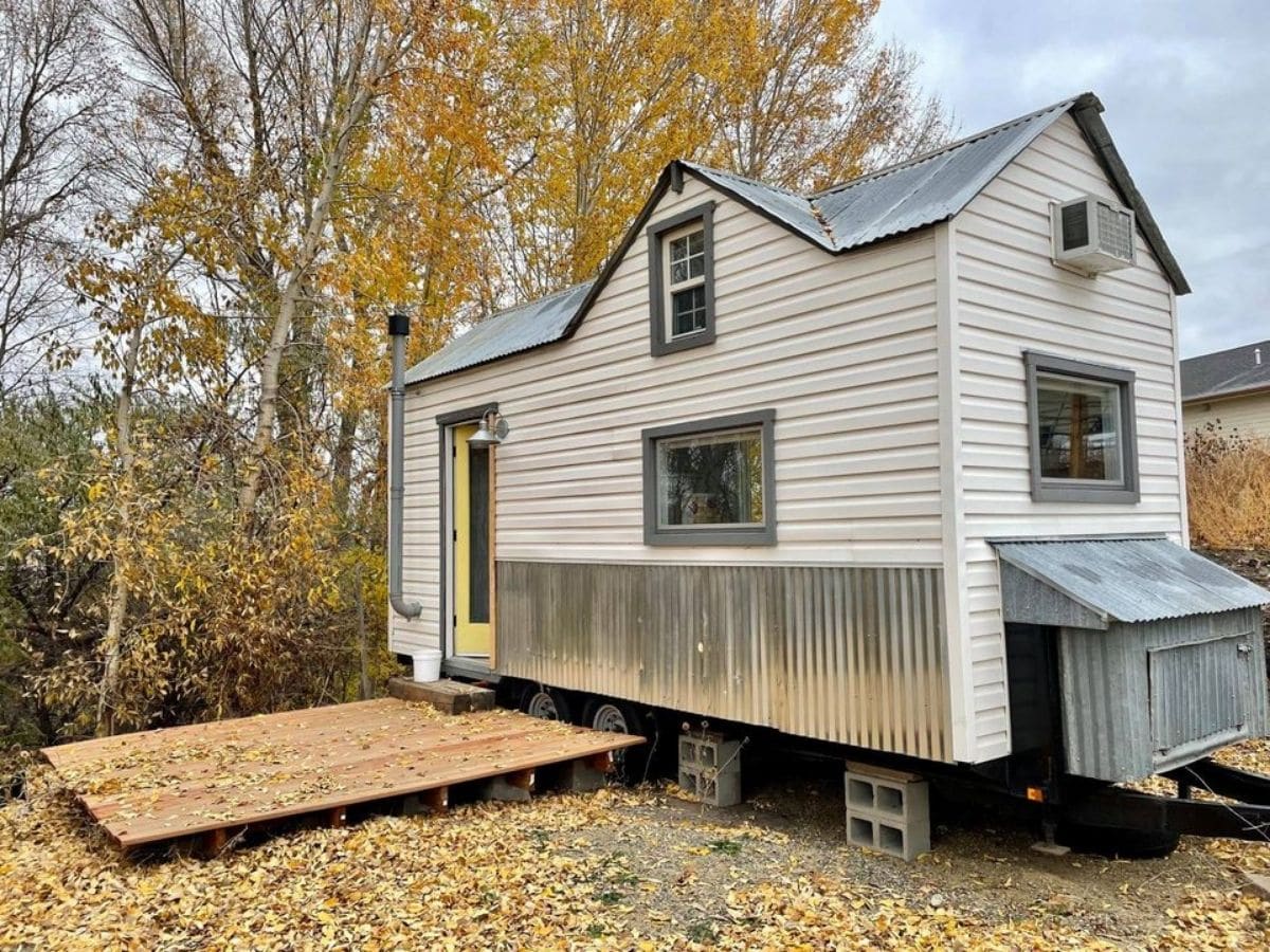 white and gray tiny home on wooded lot