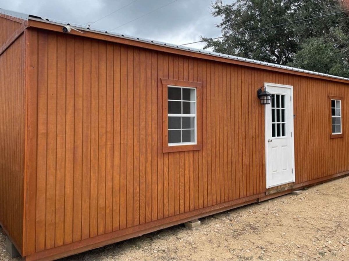 long brown shed tiny home with white door