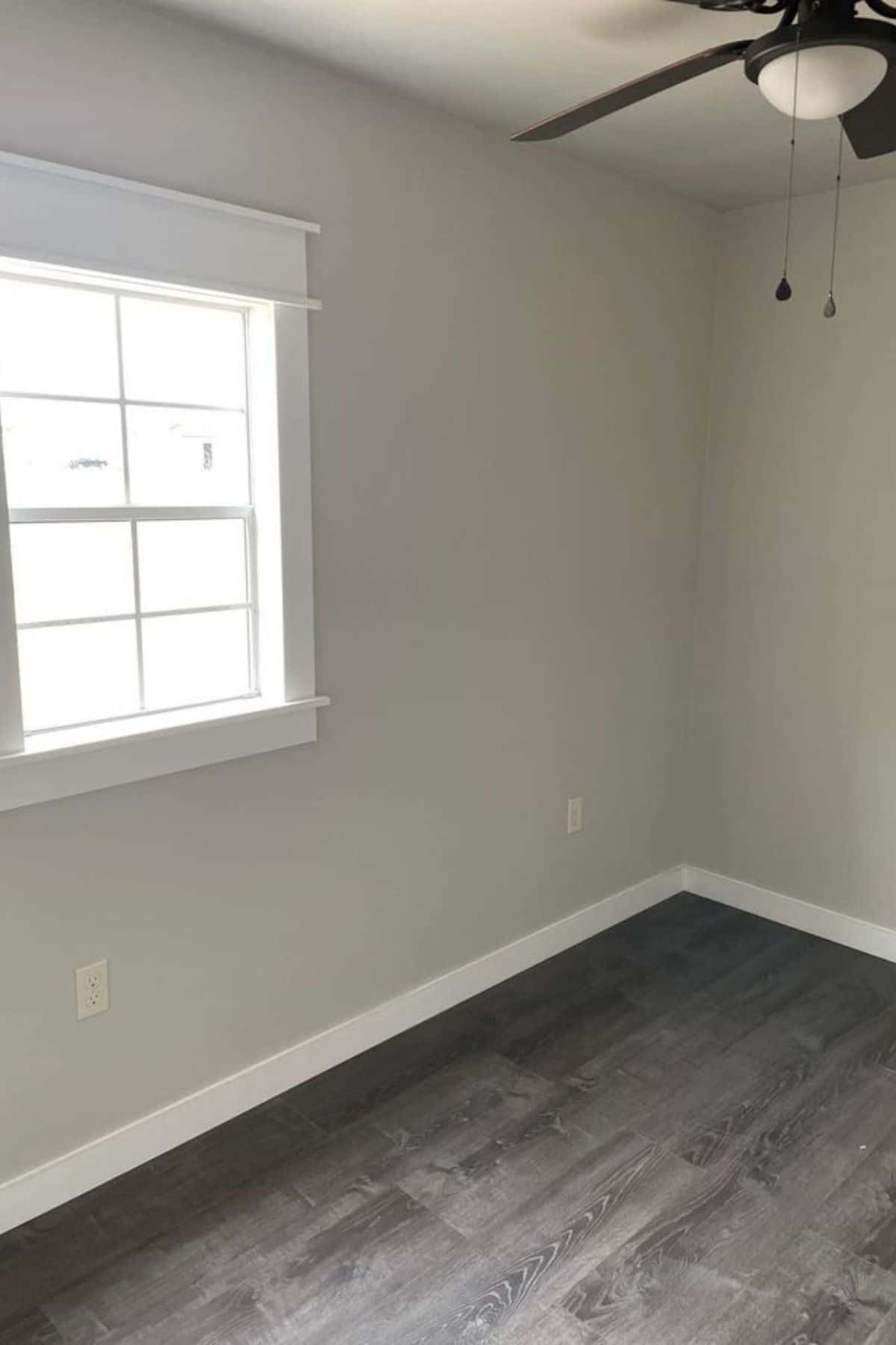 empty room with gray wood floor and light gray walls