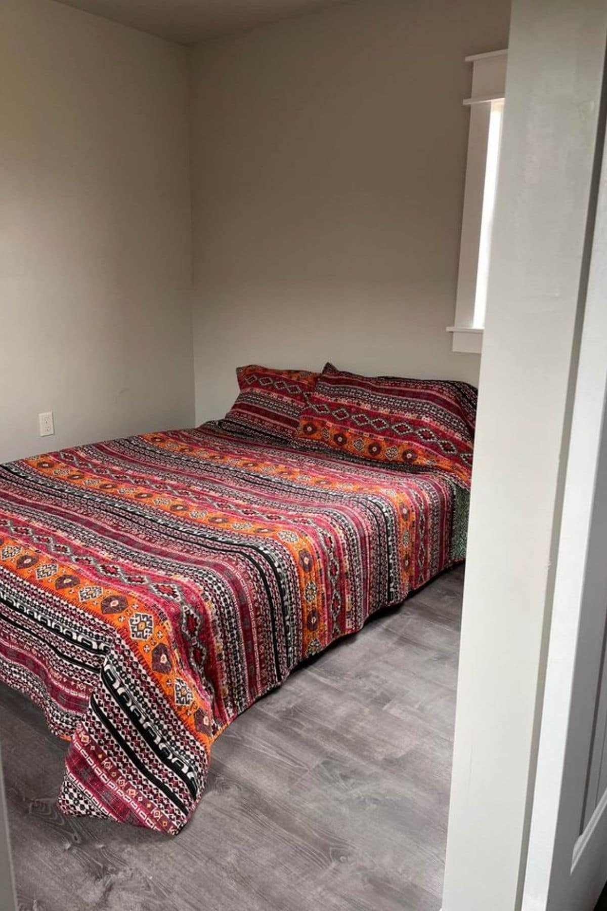 colorful bedding on bed inside door frame