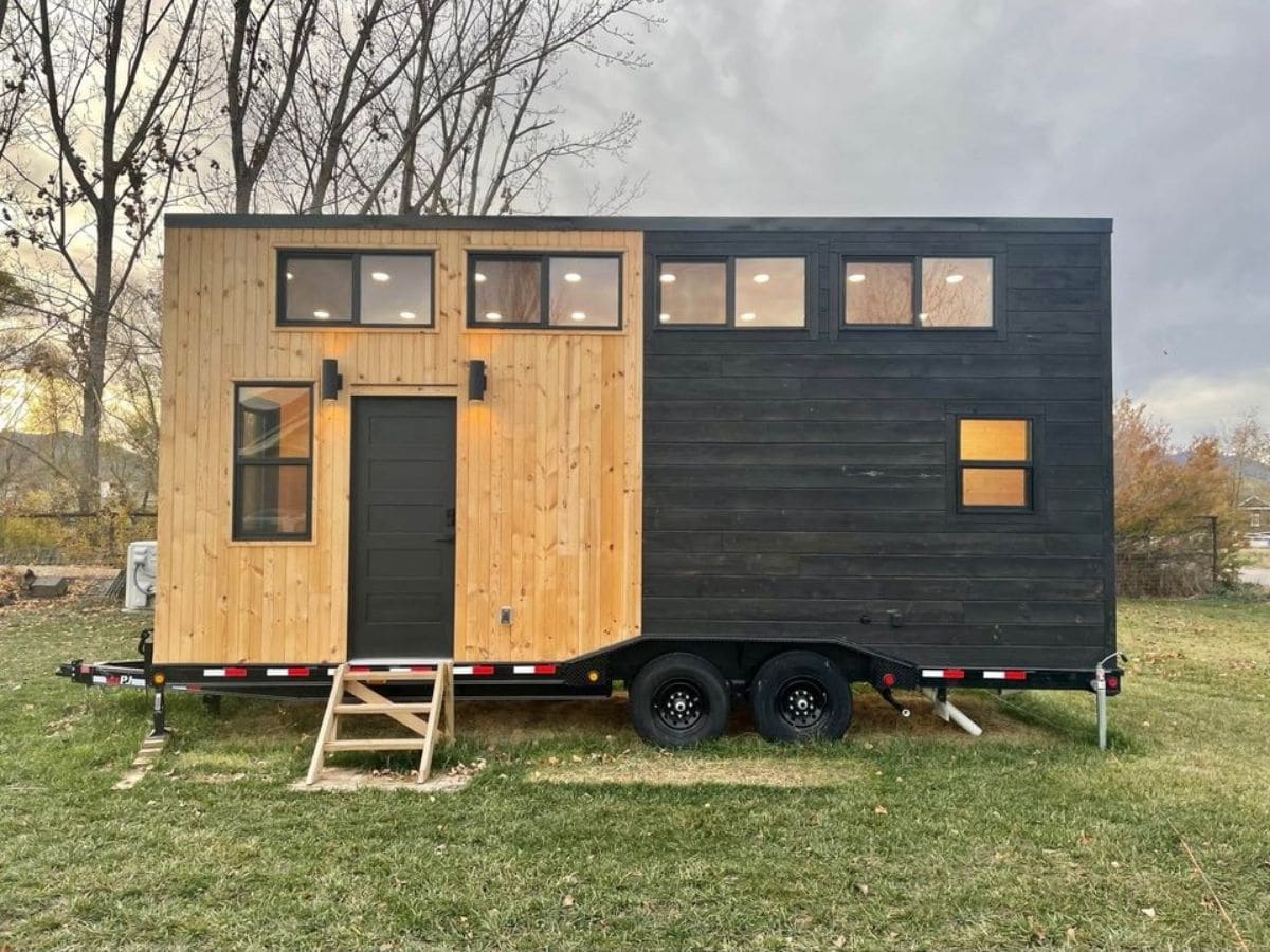 black and wood grain tiny home with short steps on front