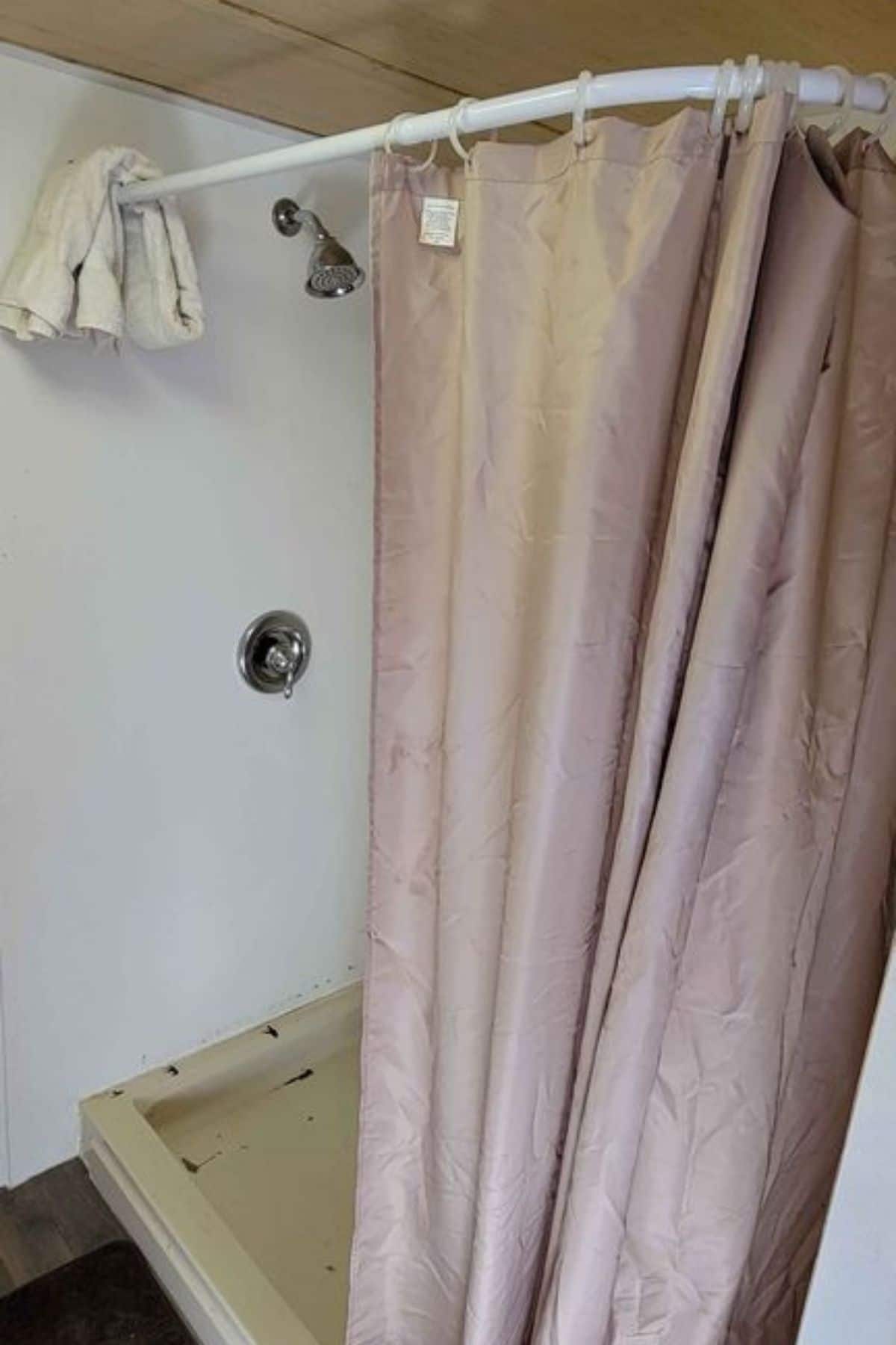 shower stall with white surround and pink shower curtain
