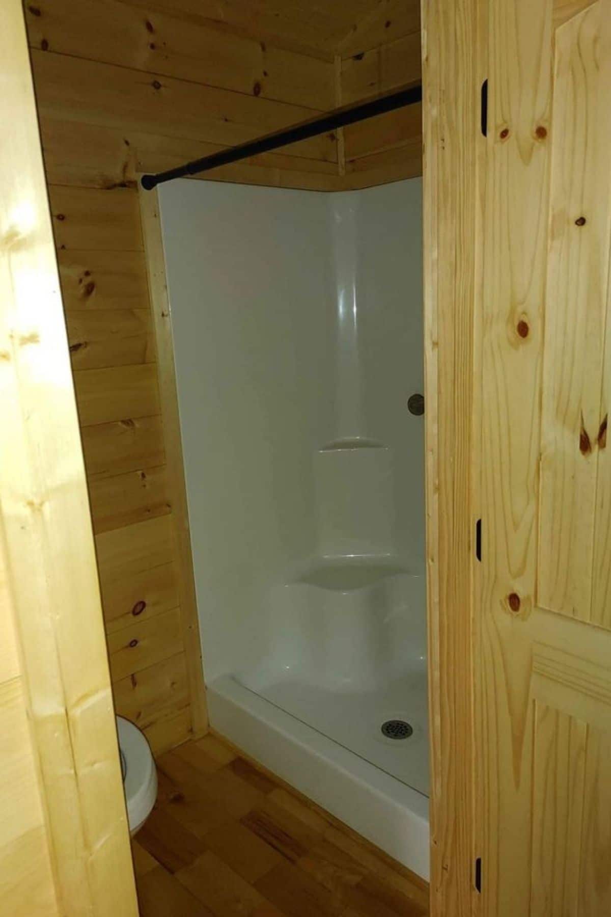 white shower stall in wood bathroom