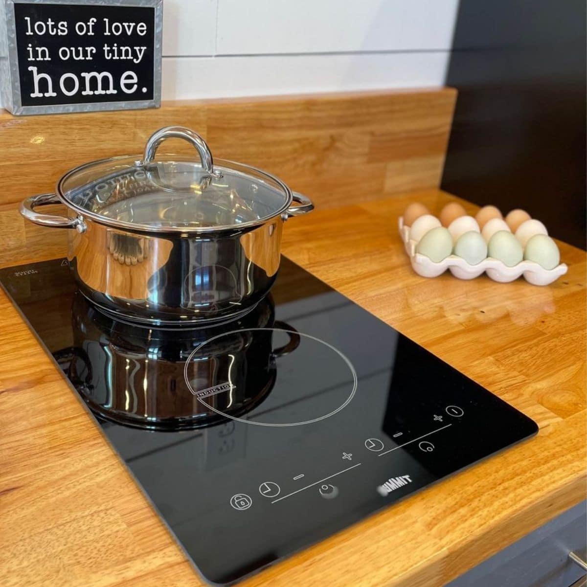 induction cooktop in butcherblock counter with pot on back burner