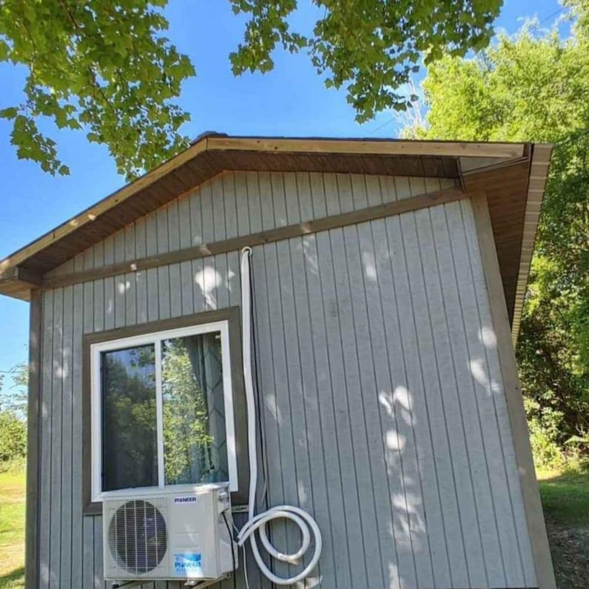 end of tiny home with air conditioner mounted below window
