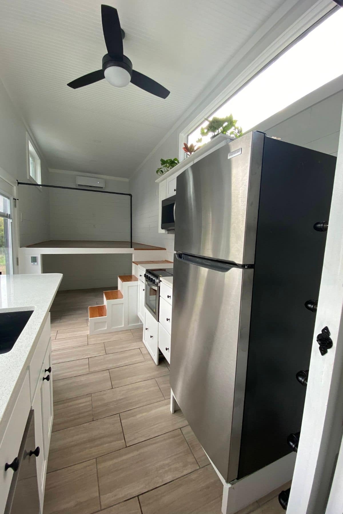 stainless steel refrigerator in foreground with white cabinets in background
