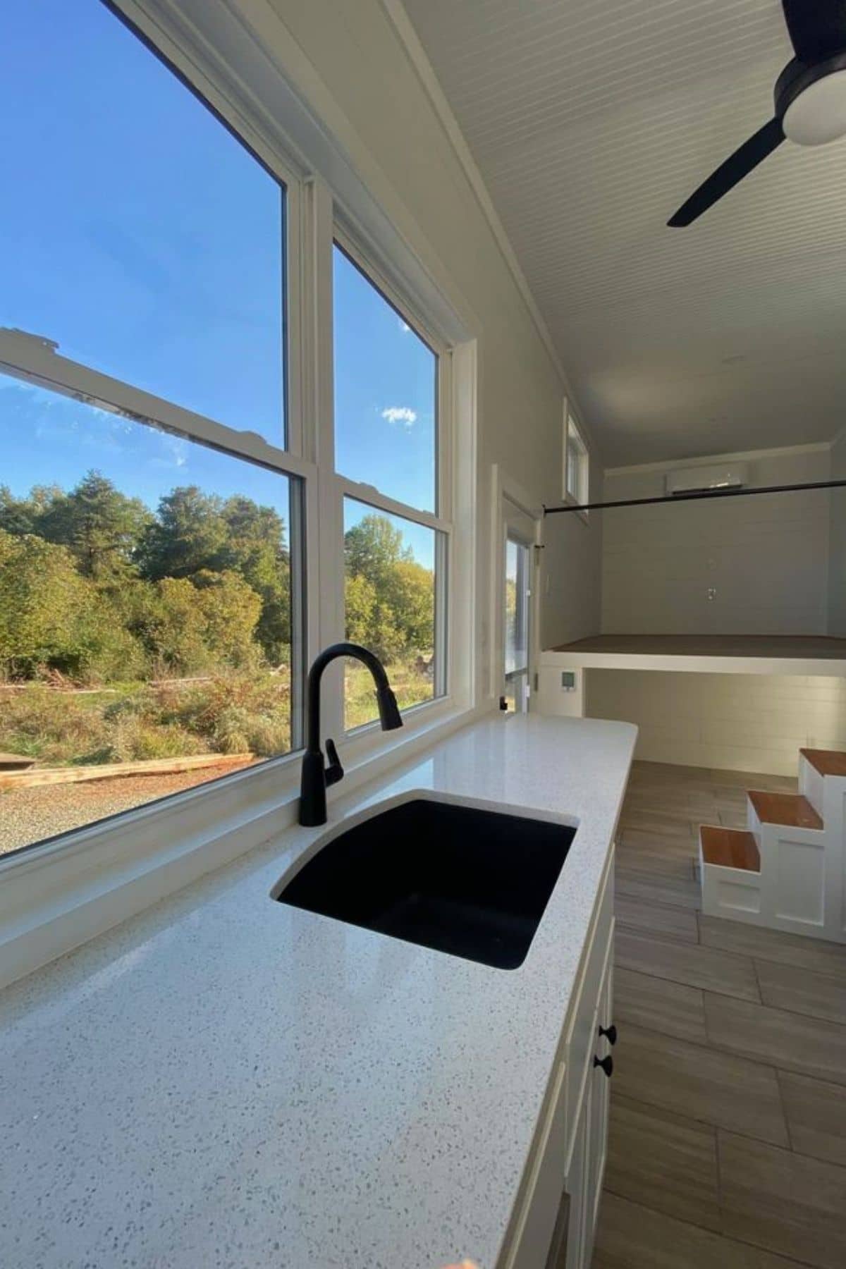 view across top of whiet kitchen counter top with black sink