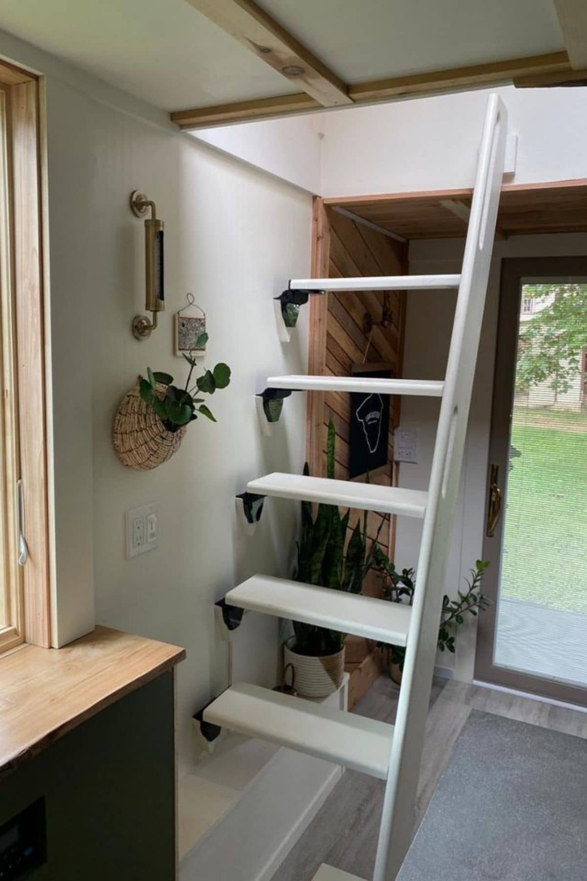 white ladder to loft against wall with glass door in background