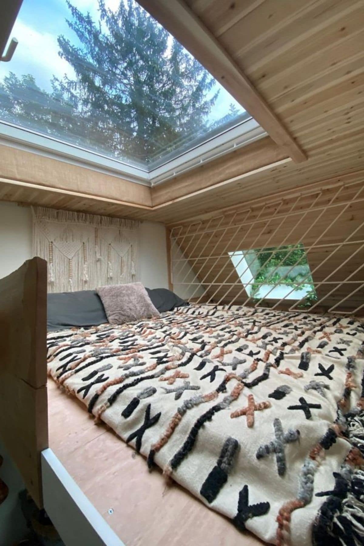 bed in loft with skylight above