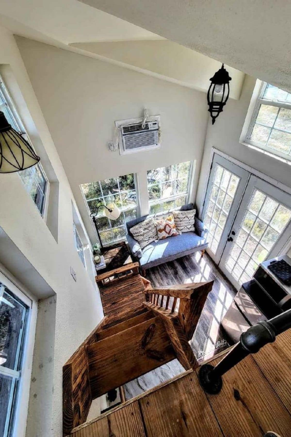 view down into tiny home living area from loft