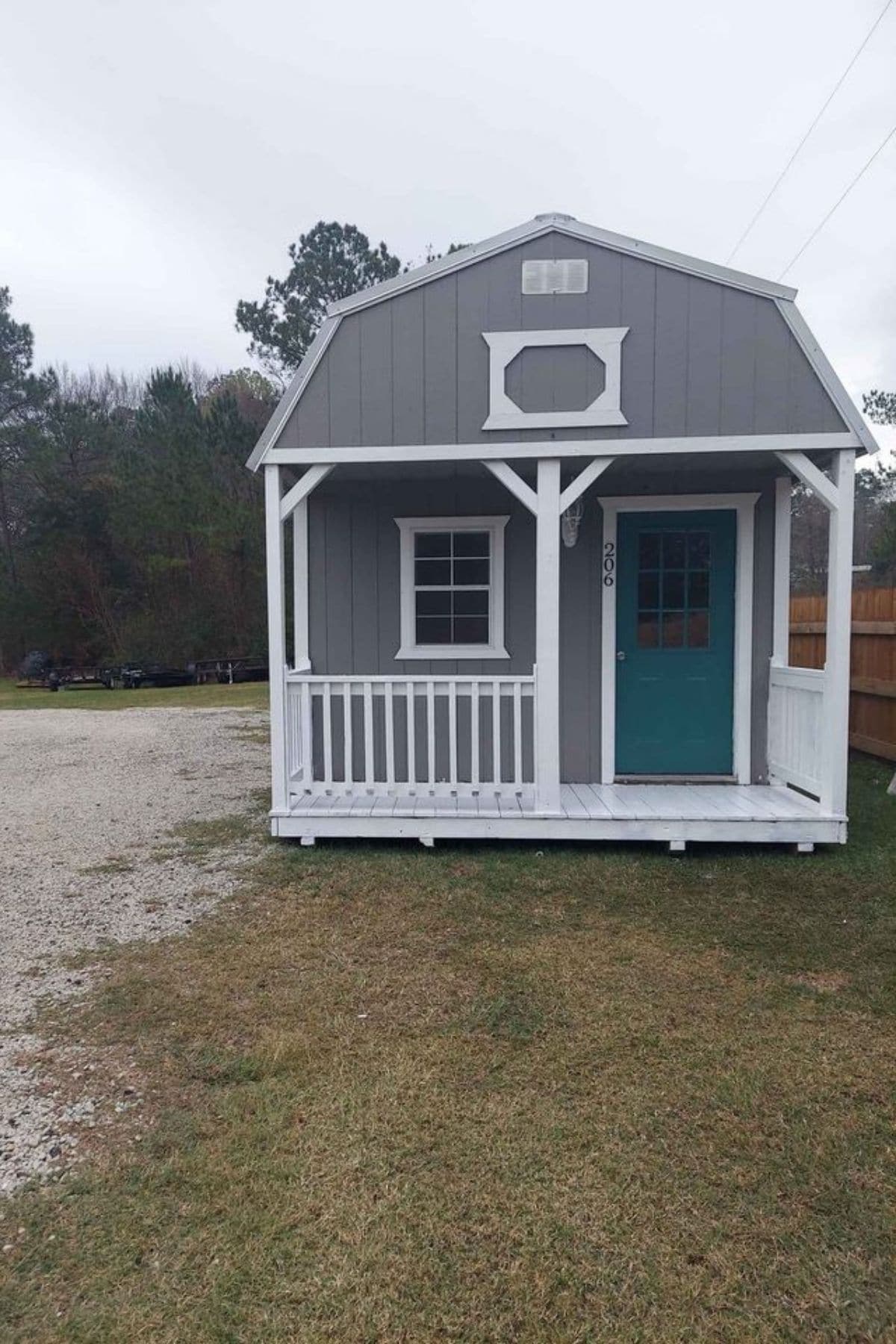front of gray cabin with teal door and white trim