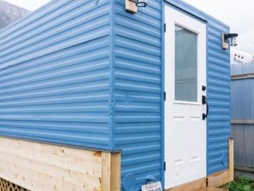 blue tiny home with white door on end