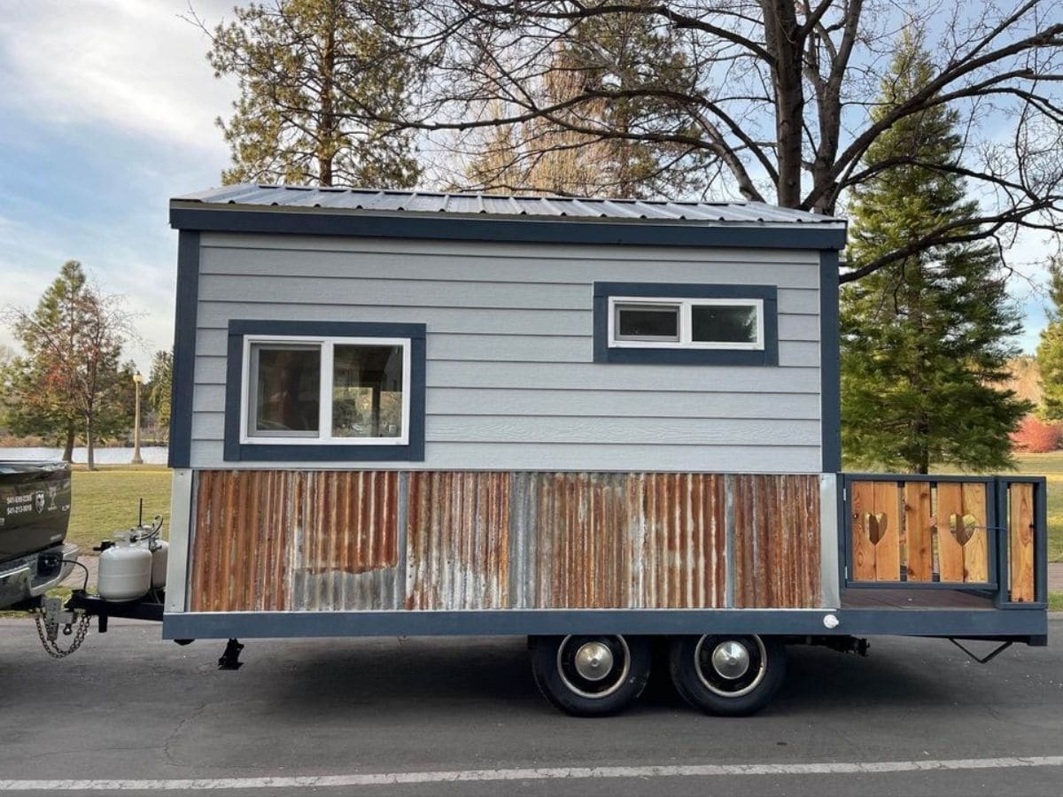 side of tiny home with corrugated metal siding on bottom half of home