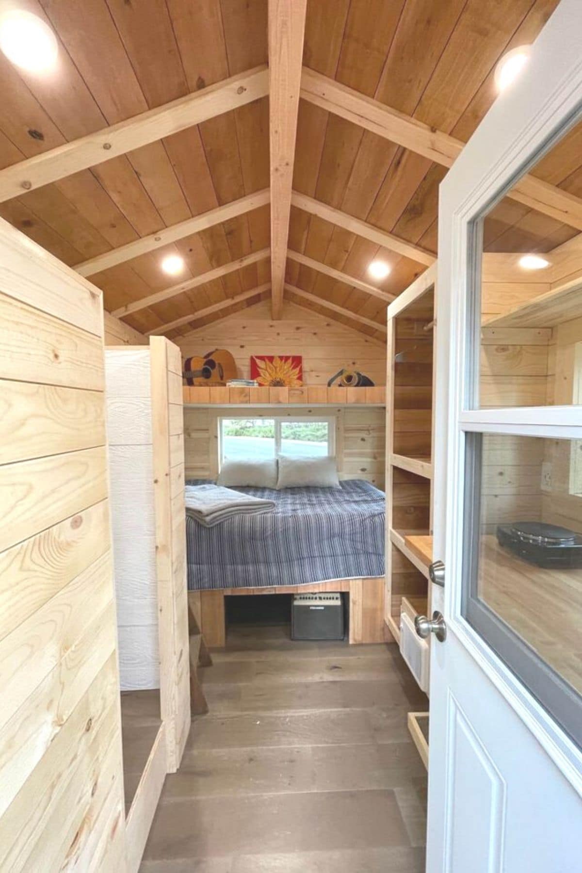 open door into tiny home with white door and light wood interior