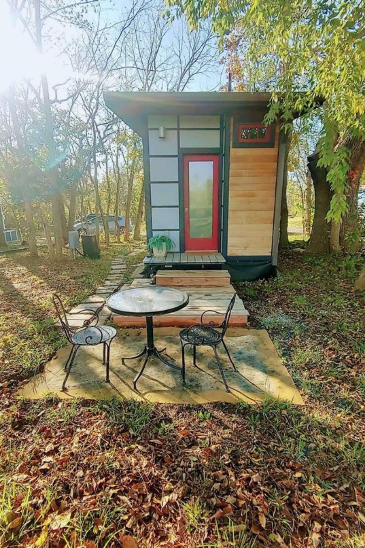 bistro set outside tiny home with red front door