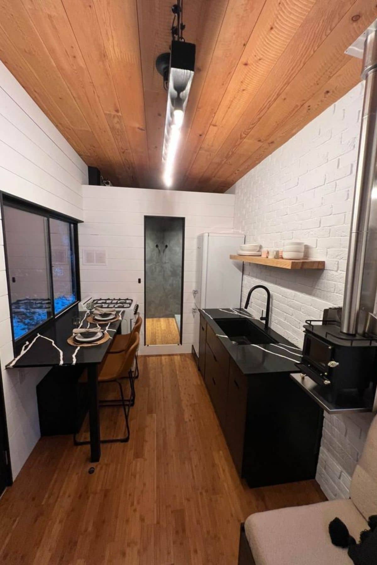 kitchen with dark cabinets against white walls in tiny home