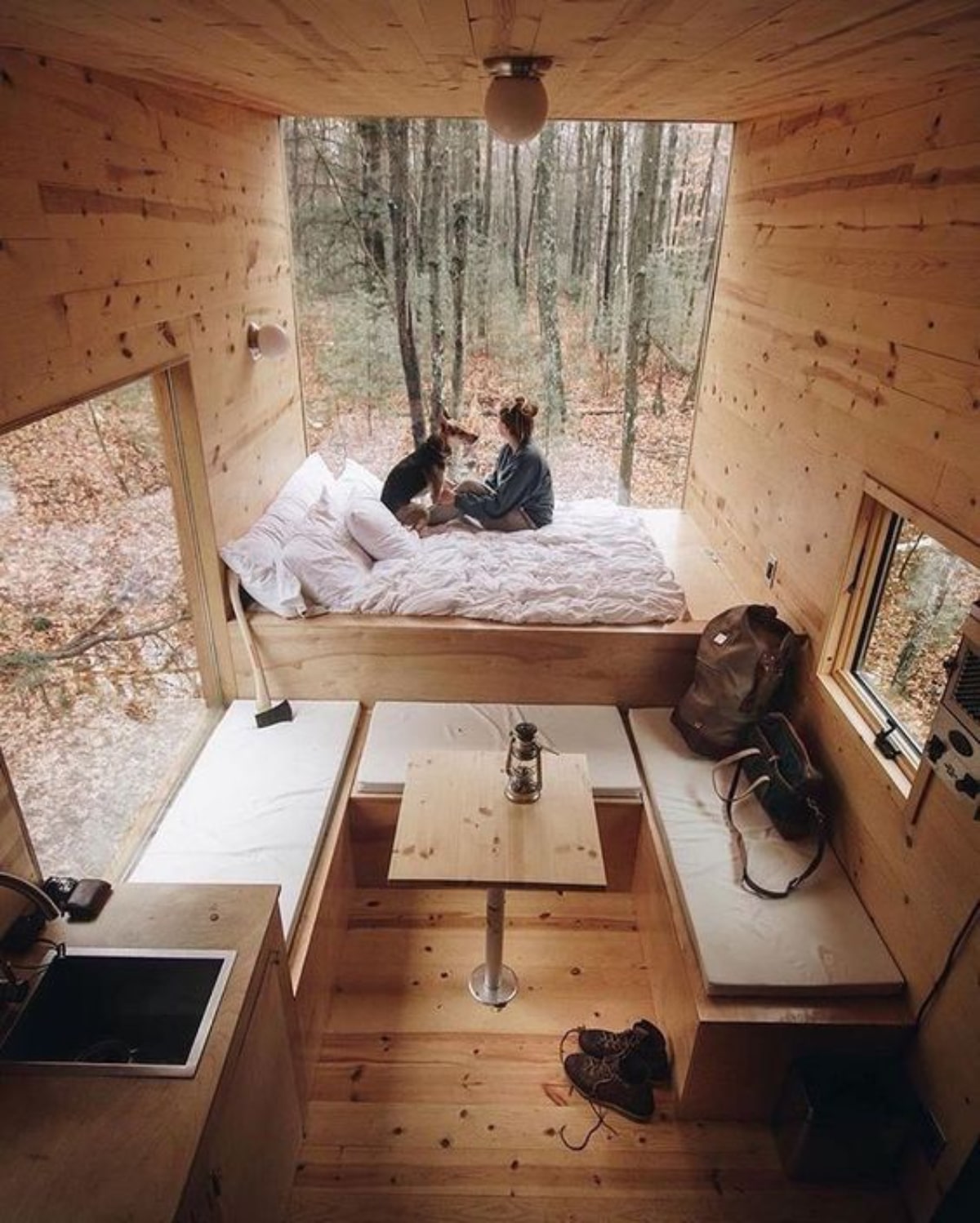 Wooden tiny house with girl and dog on the bed staring at window