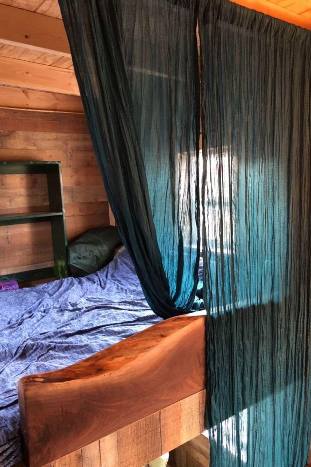 teal curtain on ceiling hiding loft sleeping space behind it