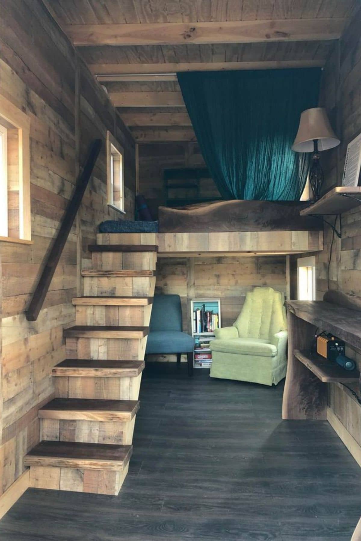 view into tiny home with stairs to loft on left of room