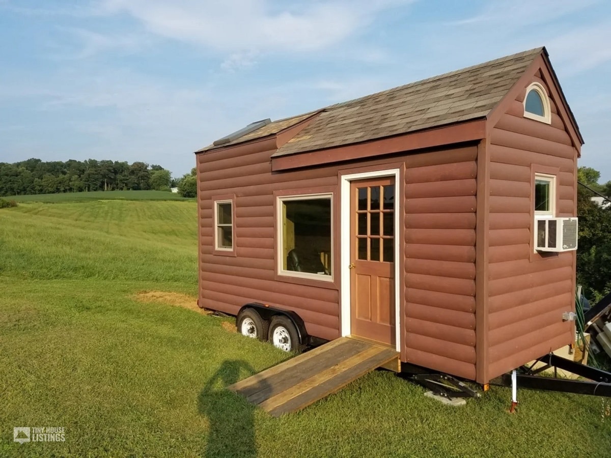 Brown color tiny house on a green field of grass