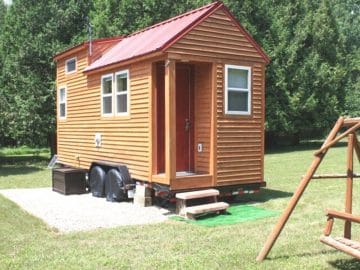 tiny log cabin with door awning and red roof