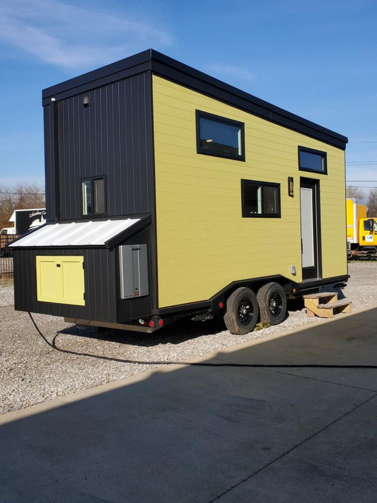 lime green and black tiny home with small storage at back of home