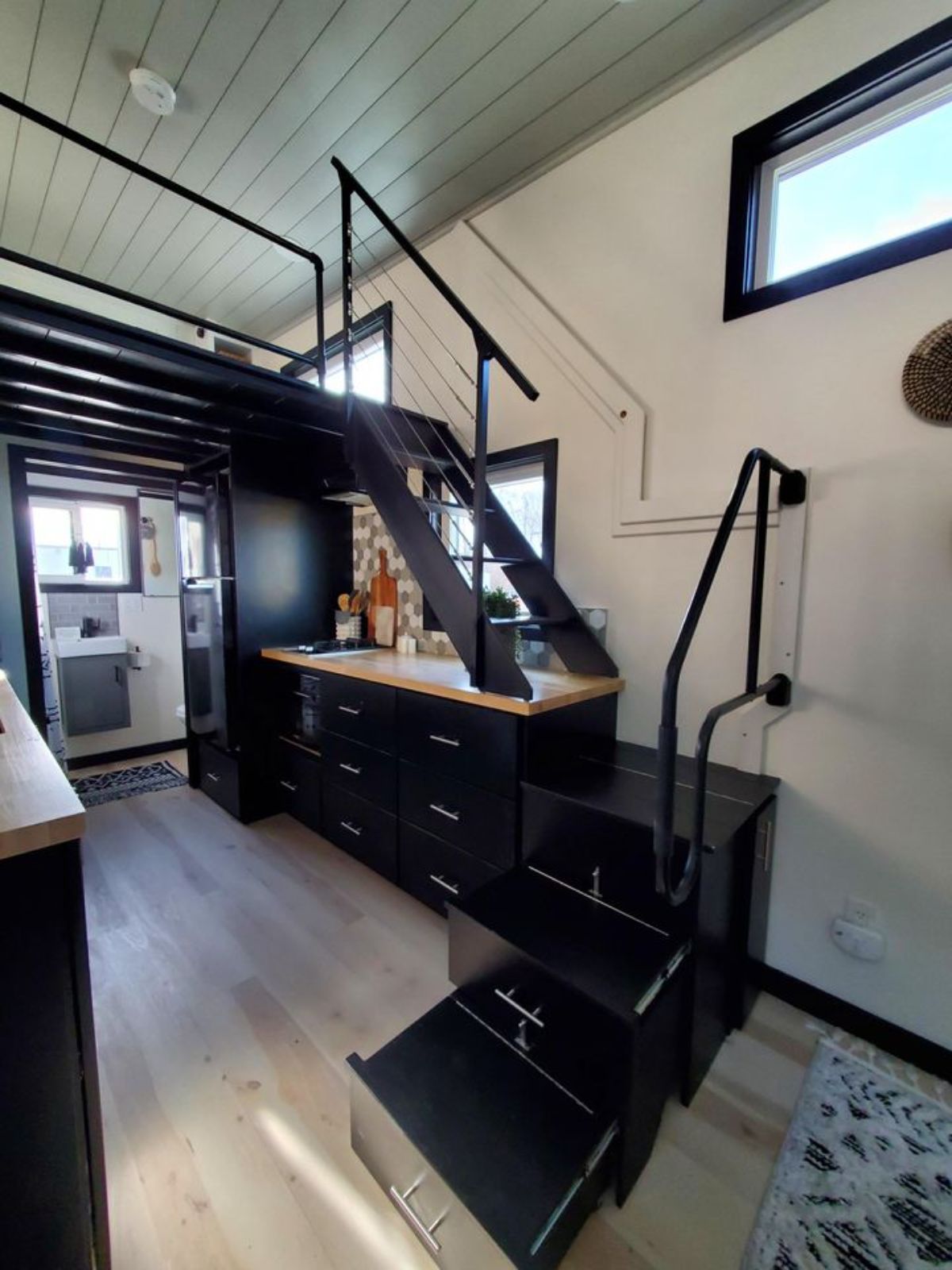 black stairs to loft against white wall inside tiny home