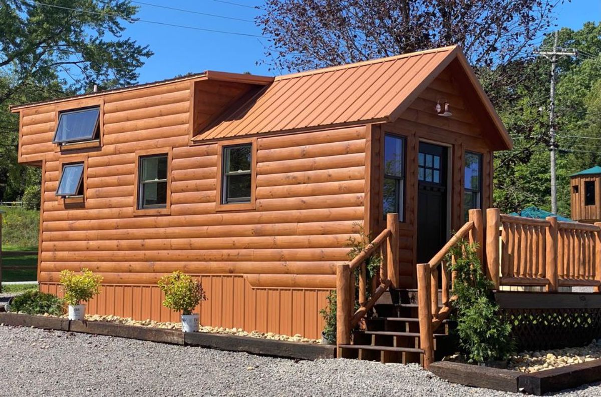 log siding on tiny home with wood porch on front