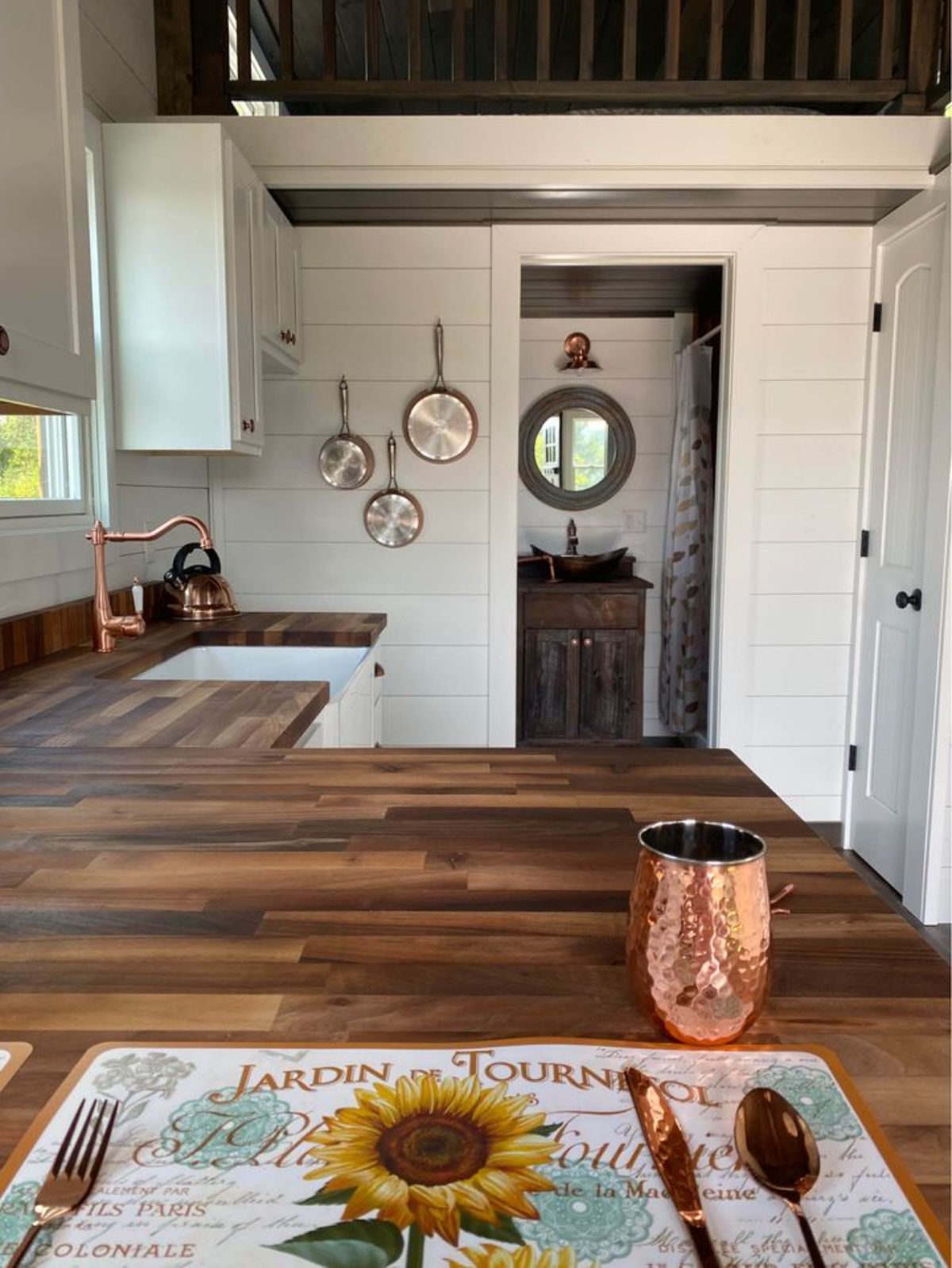 brown wood butcher block countertop in kitchen with copper cup by placemat