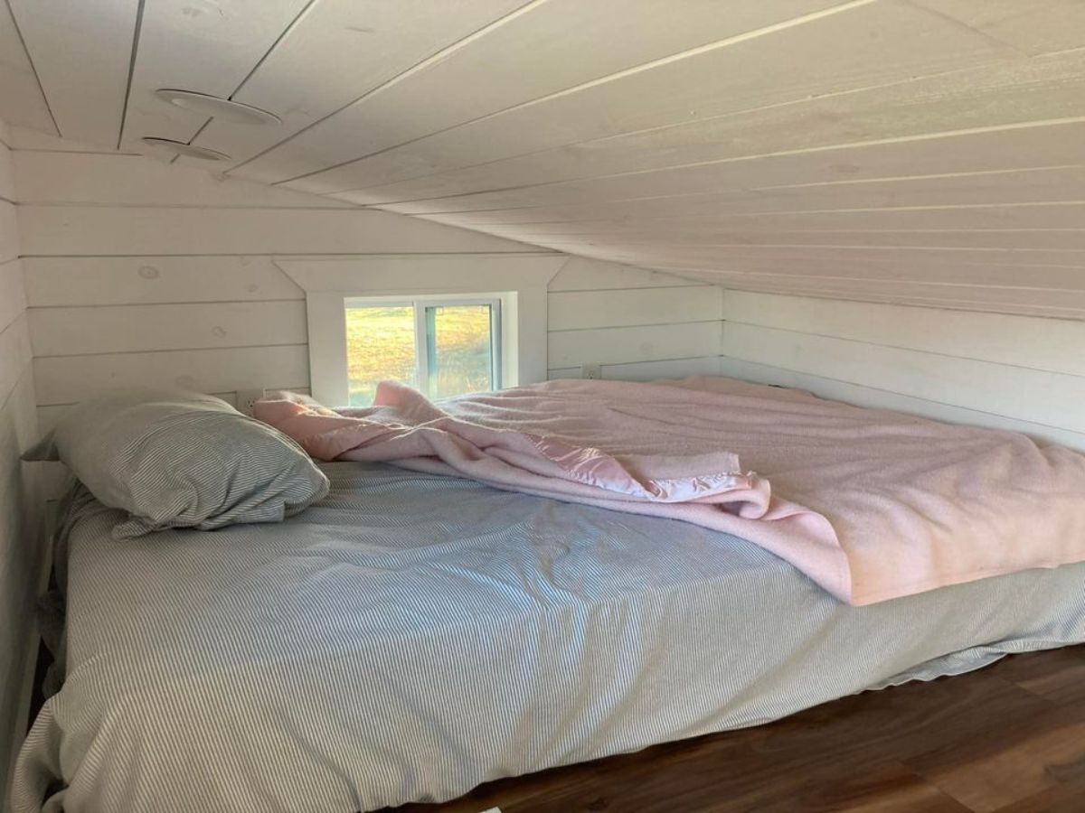 bed in loft with pink and white bedding