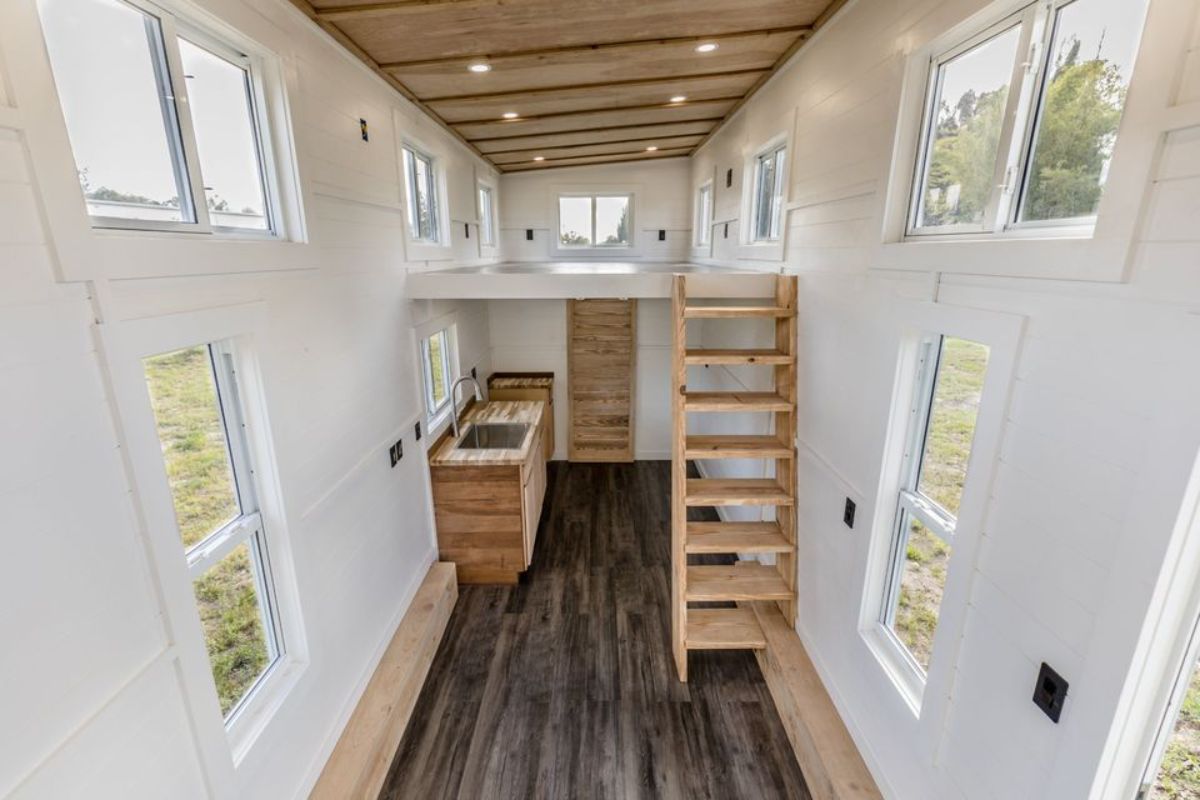 view across tiny home with white walls and dark wood floor and ceiling