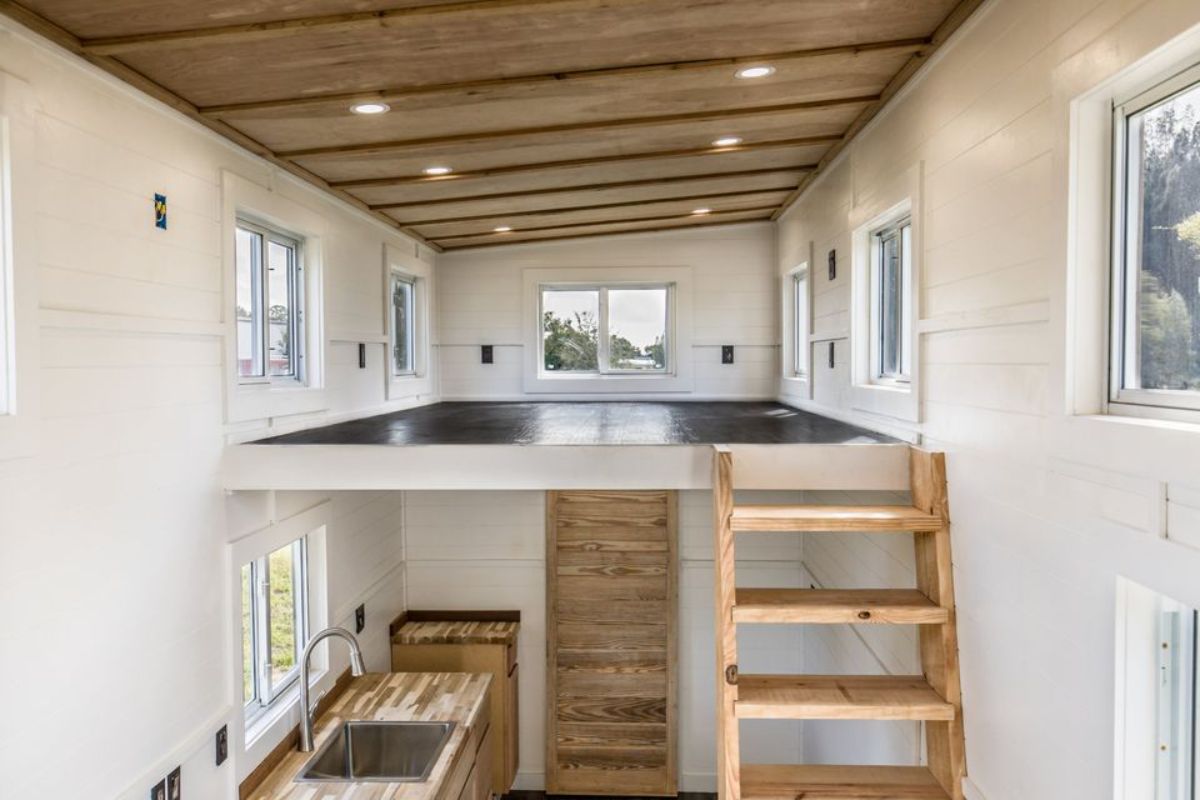 open loft with dark wood floor and white walls