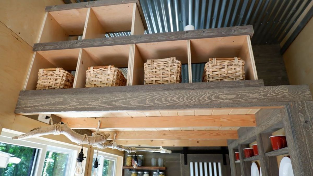 baskets in open cubbies hanging from ceiling in tiny home