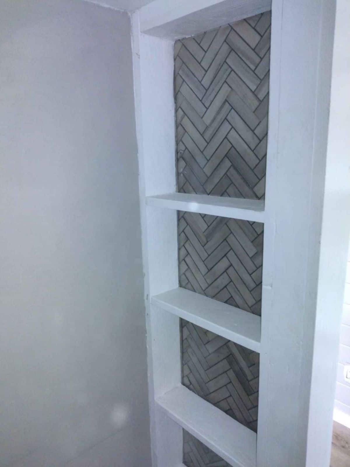 shelves with tile backsplash inside kitchen