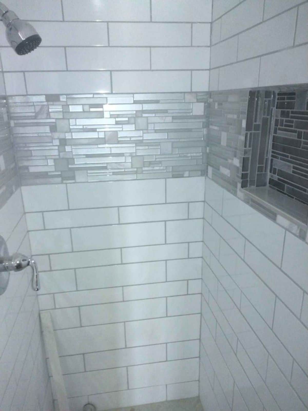 white and silver tile in shower of tiny home