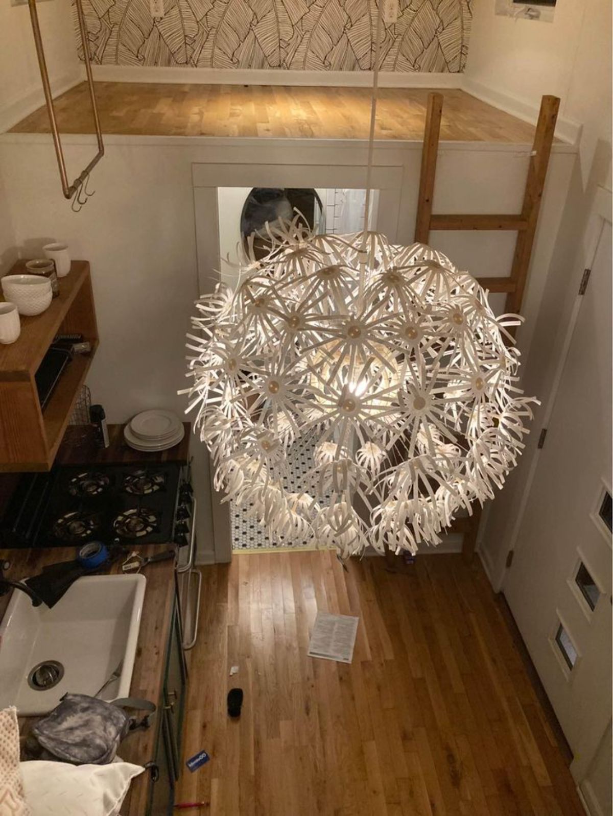 white starburst chandelier lantern in middle of log cabin