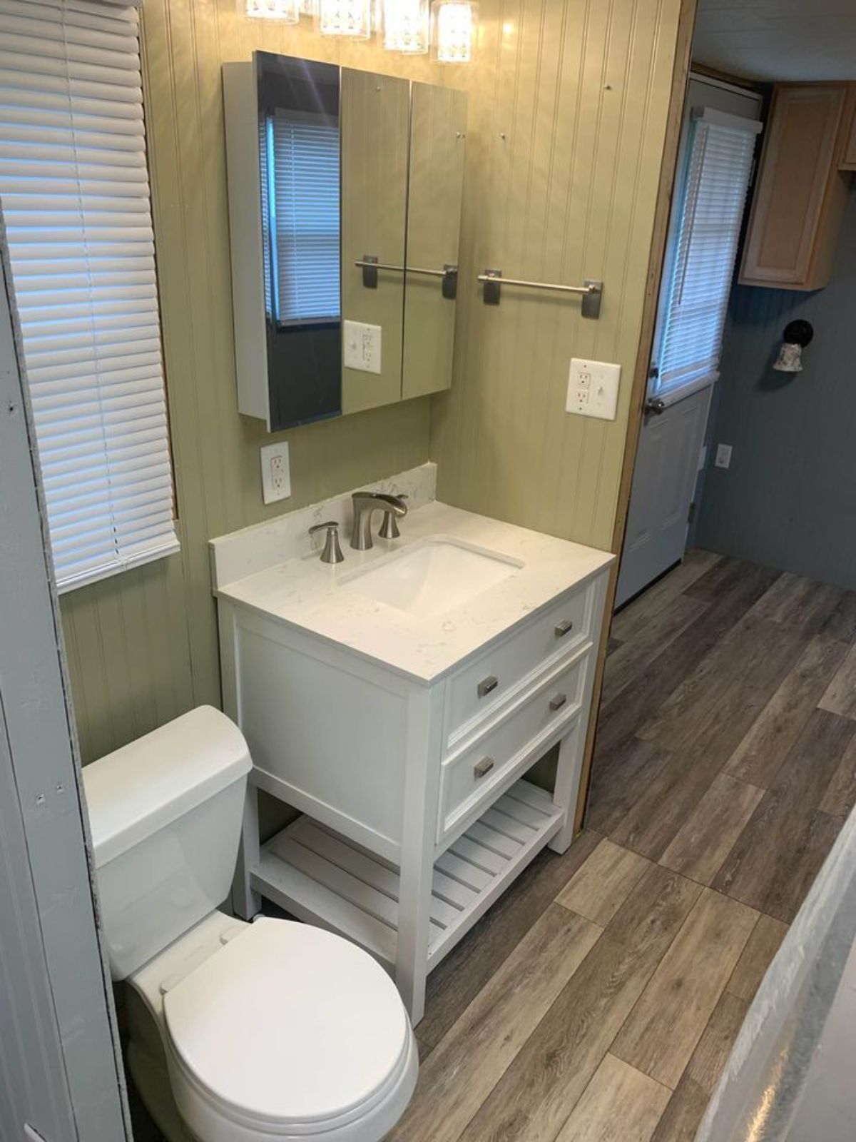 light gray walls in tiny house bathroom with white vanity and sink