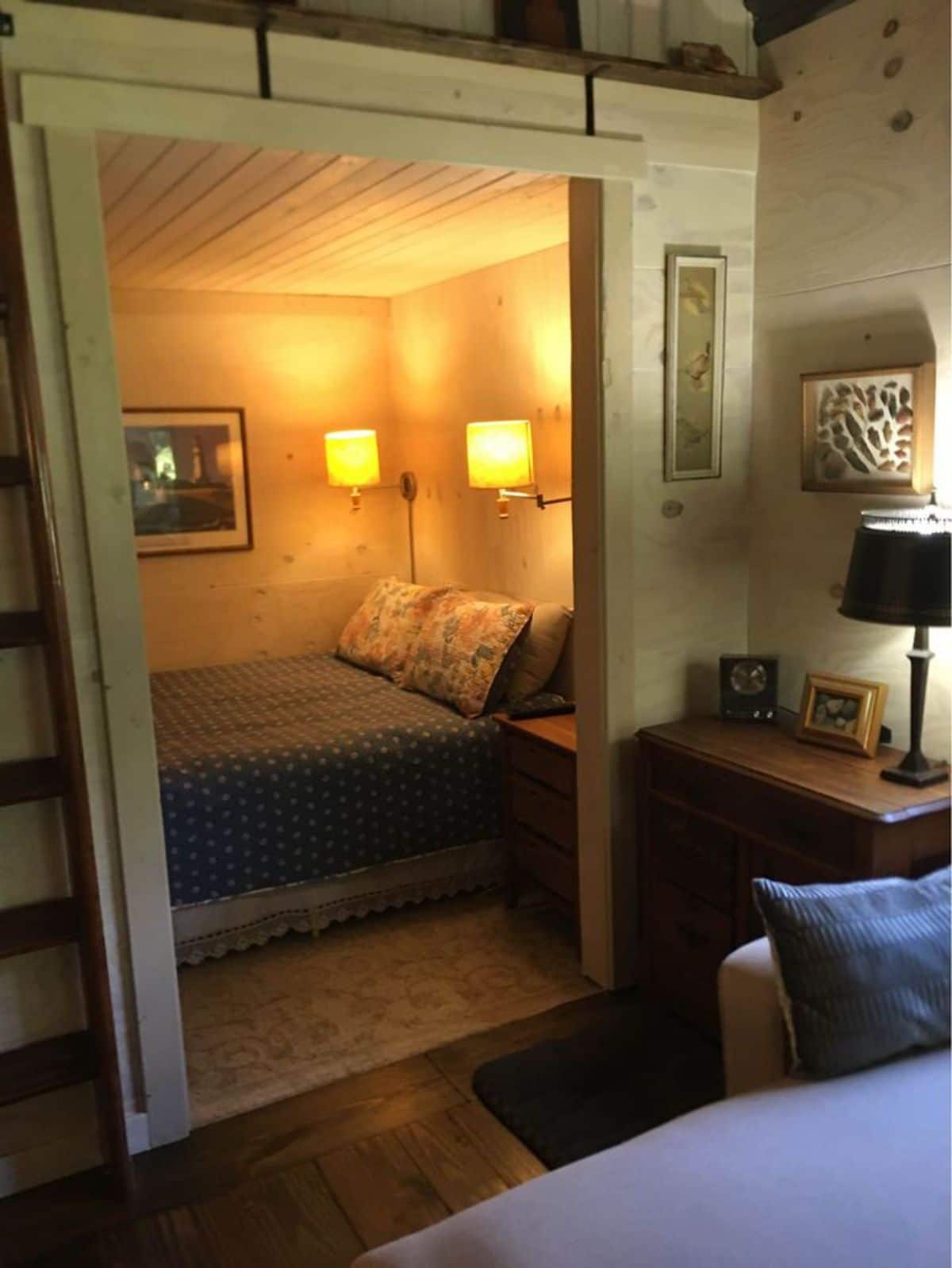 open door to bedroom showing blue bed under two lights